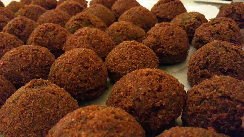 Rows of freshly fried falafel balls with a dark, crisp golden-brown crust