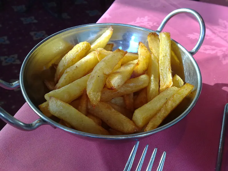 Golden chunky chips piled in a small metal serving dish
